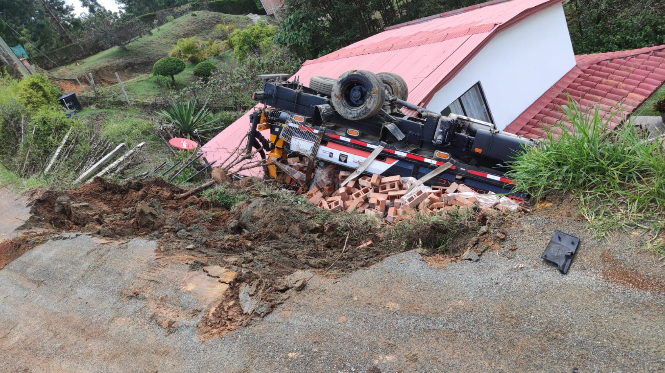 Susto en Guarne: un camión cargado de ladrillos cayó sobre una vivienda